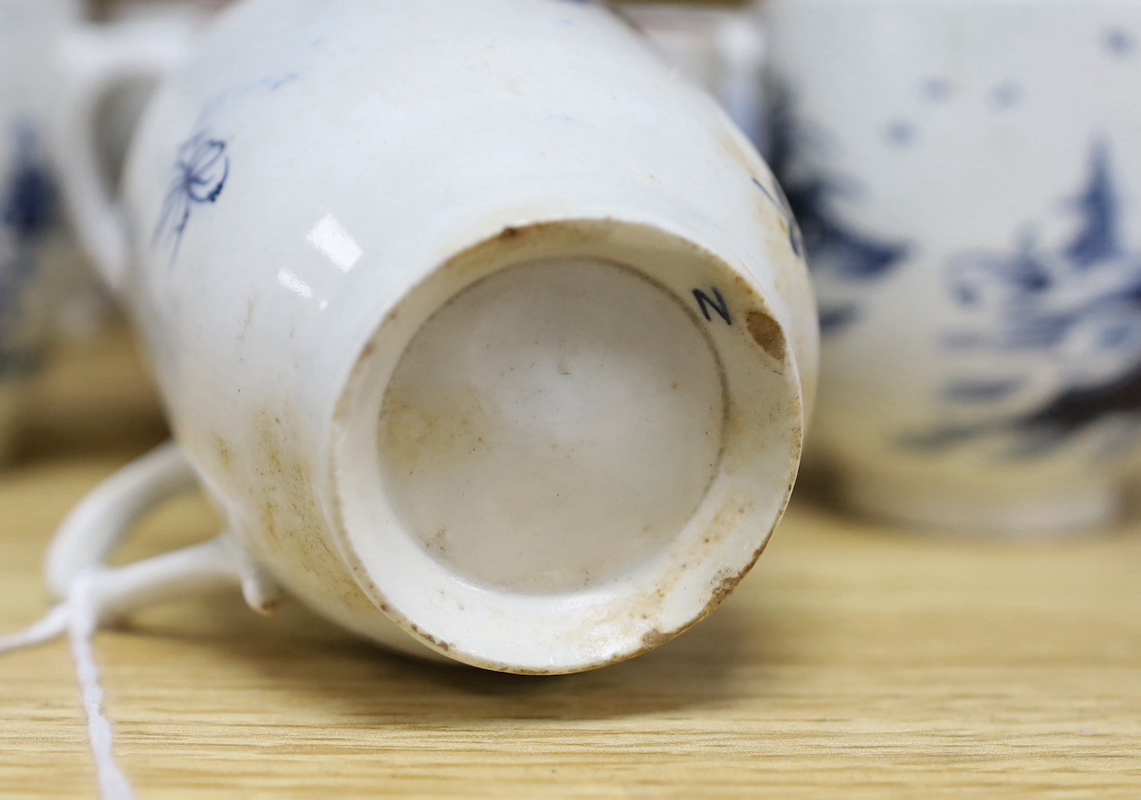 Seven various English porcelain coffee cups, including two Bristol enamelled with green floral sprays, two Bow painted in underglaze blue with a bird in a Chinese garden, and three Worcester/Bow in underglaze blue.